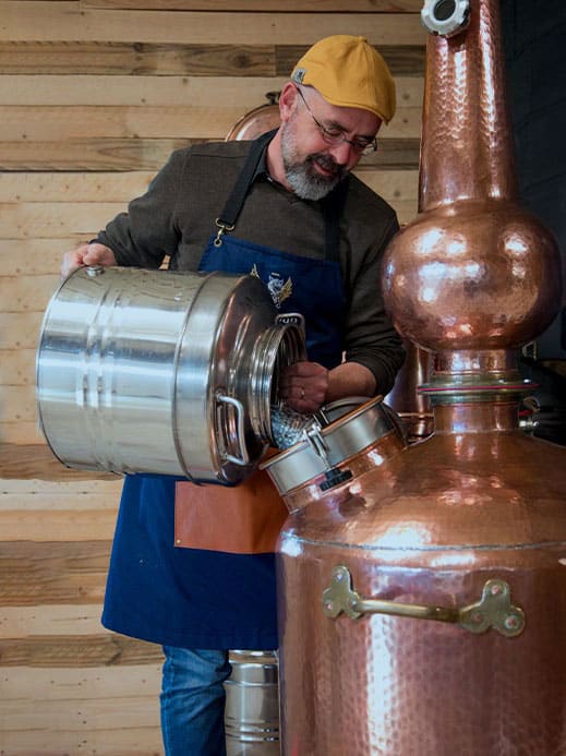 travaille de distillation sur un alambic en cuivre à repasse